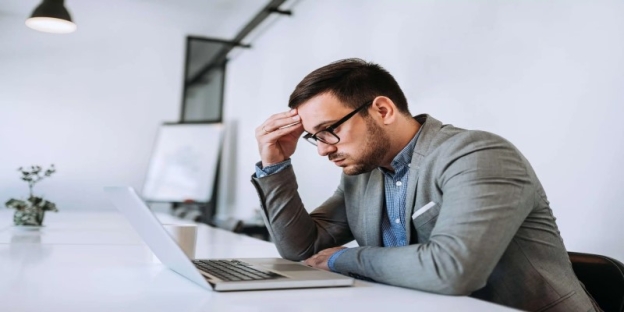 A person in a suit looking at a computer AI-generated content may be incorrect.
