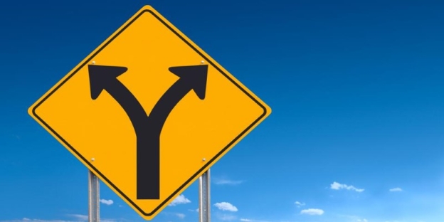 A yellow road sign with black arrows AI-generated content may be incorrect.